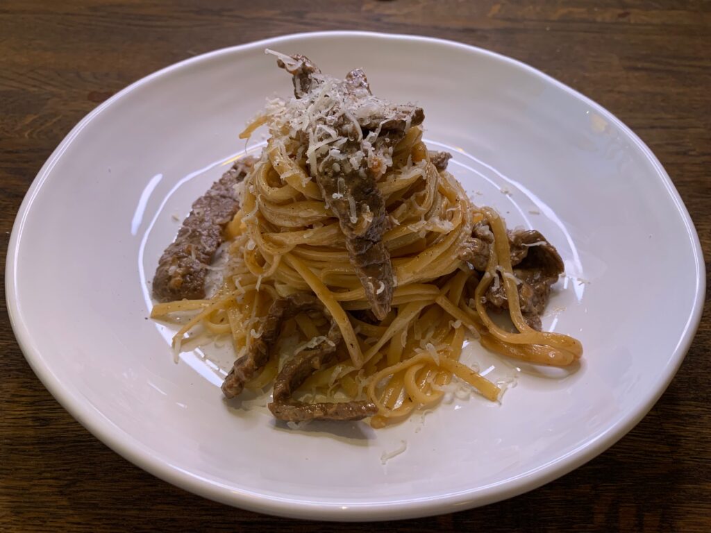 Krämig linguine och lövbiff på vit tallrik