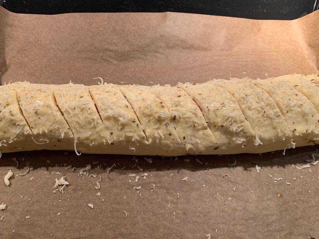 Rullad pizzadeg toppad med finriven parmesan.